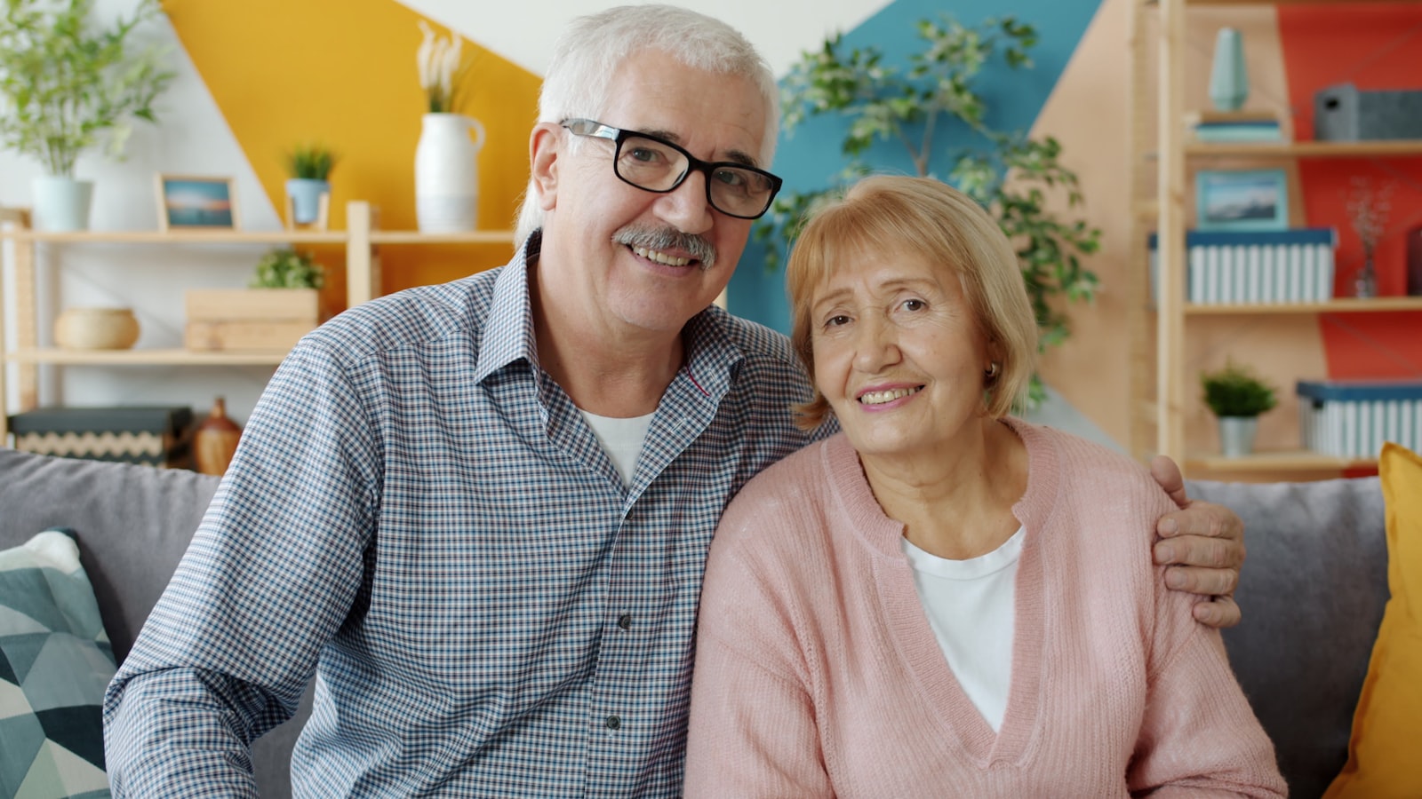 An older couple sitting together at home, reviewing insurance options on a laptop